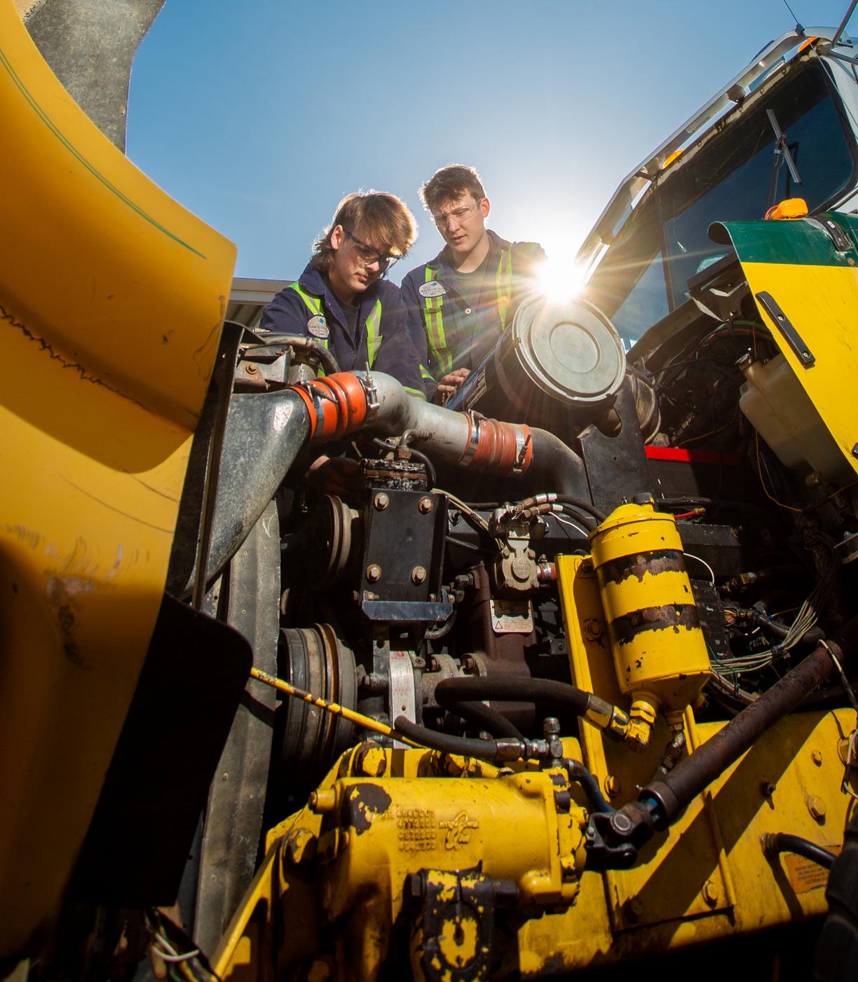 2 students fixing a truck engine